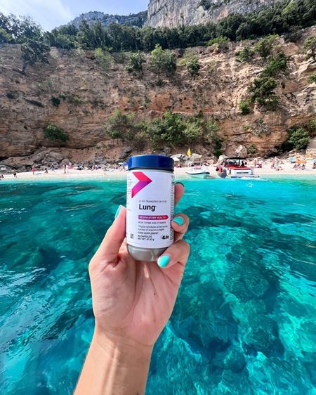 person holding a packet of TF Lung on a beach